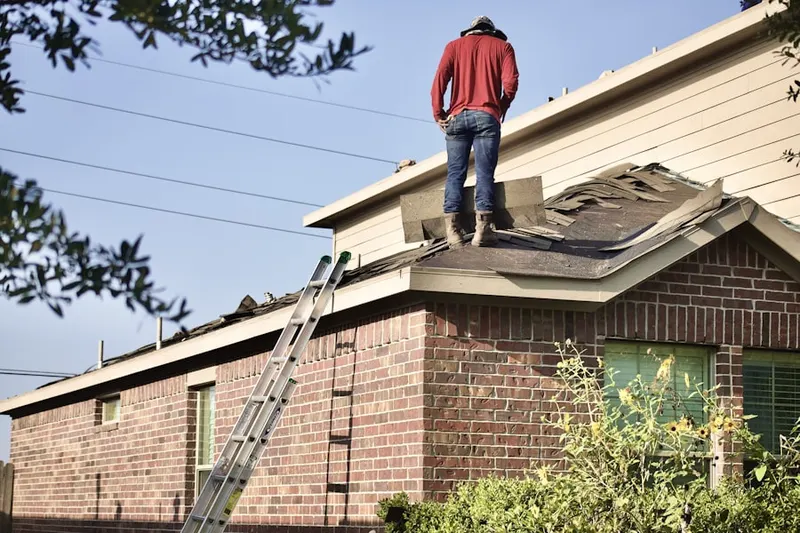 Professional roofer working on a residential roof in Mission Hill